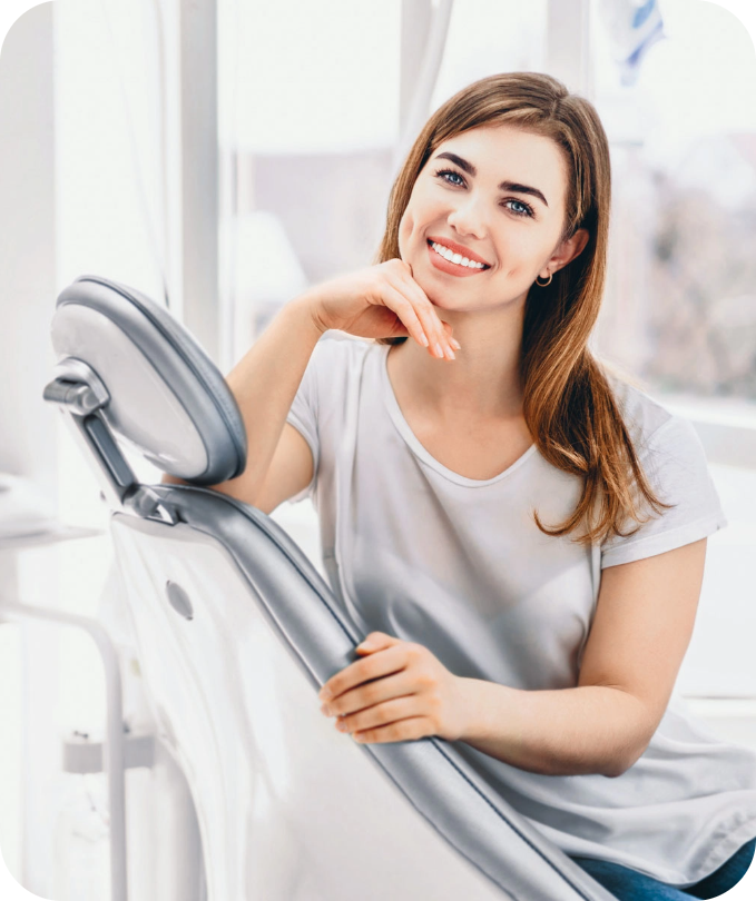 A smiling woman sitting in a dental chair, showcasing confidence and satisfaction after a professional dental appointment.