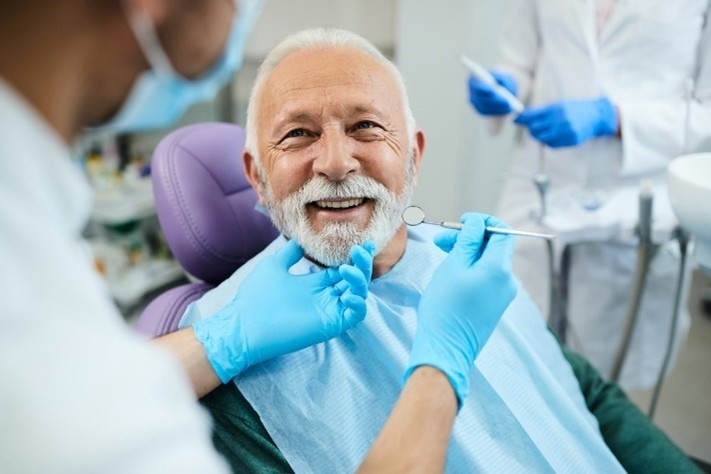 Senior patient smiling during a dental exam